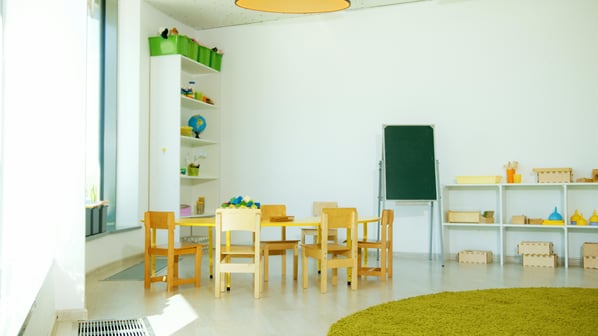 A preschool classroom layout with wooden furniture and colorful toys.