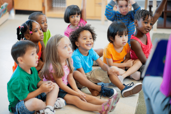 group of young kids listening to teacher