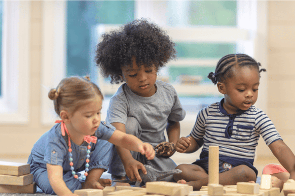 Implementing restorative practices in the classroom as three children playing with wooden blocks